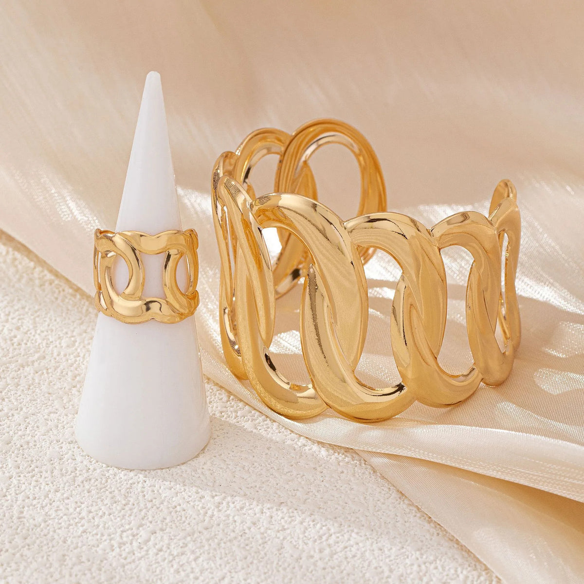 Bracelet and ring set with a geometric design of intertwined and sinuous links, with an adjustable opening