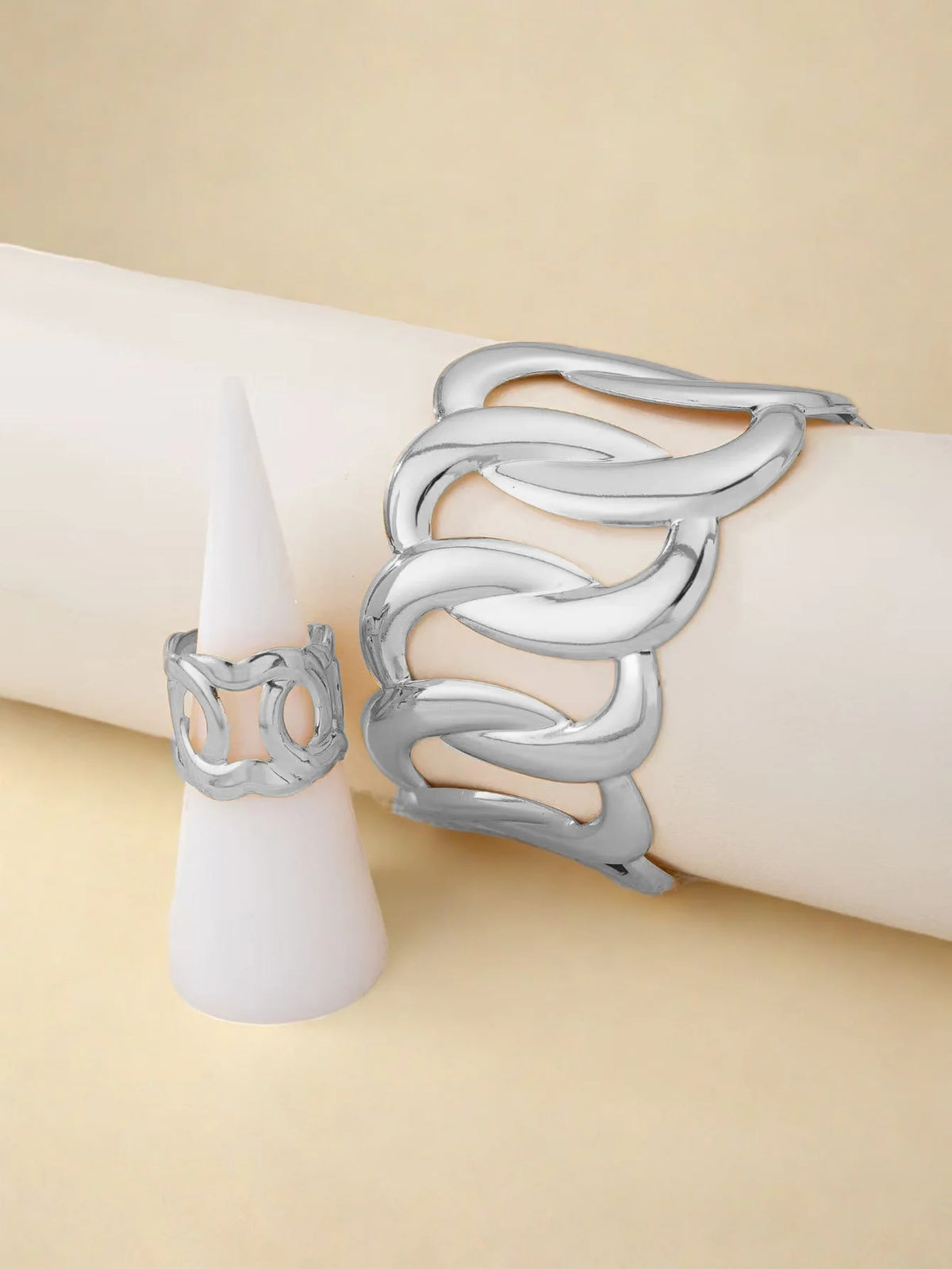 Bracelet and ring set with a geometric design of intertwined and sinuous links, with an adjustable opening