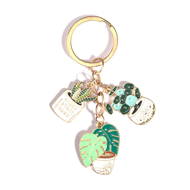 Cute enameled cactus keychain in a pot with green plants