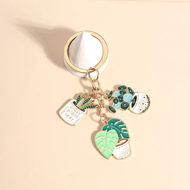 Cute enameled cactus keychain in a pot with green plants