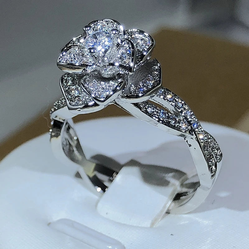 Elegant women's ring in premium 925 sterling silver featuring a three-dimensional design of intertwined roses and white cubic zirconia