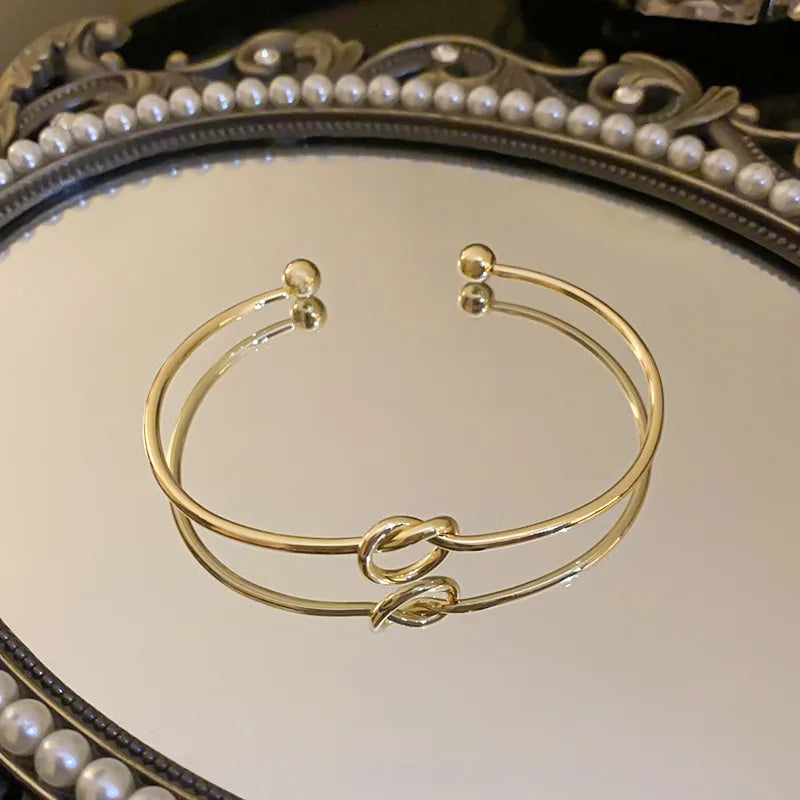Women's rigid stainless steel bracelet with knot detail