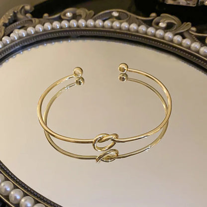 Women's rigid stainless steel bracelet with knot detail