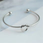 Women's rigid stainless steel bracelet with knot detail