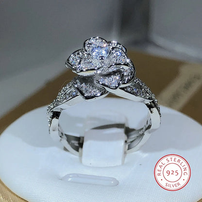 Elegant women's ring in premium 925 sterling silver featuring a three-dimensional design of intertwined roses and white cubic zirconia