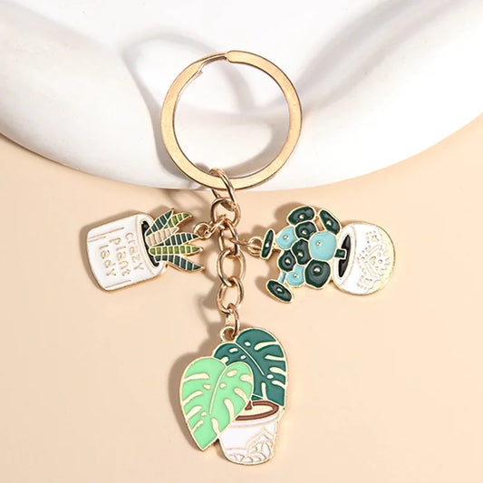 Cute enameled cactus keychain in a pot with green plants