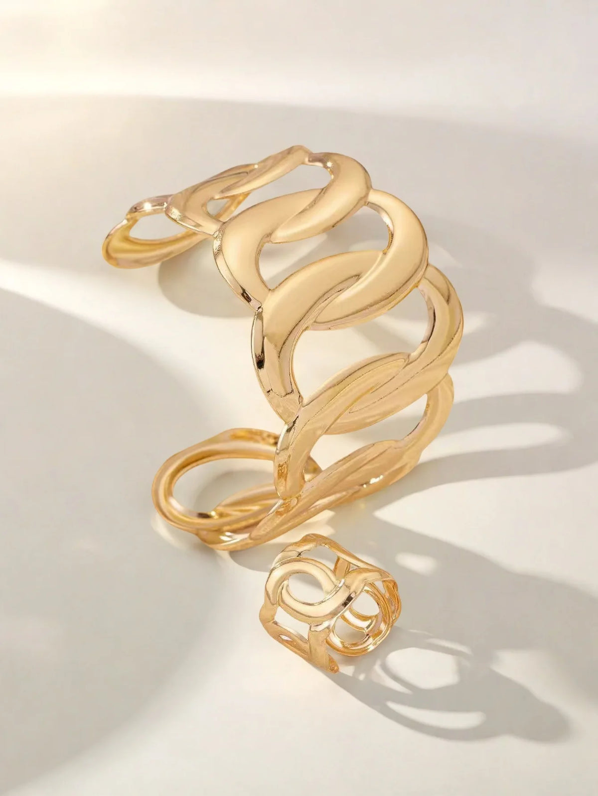 Bracelet and ring set with a geometric design of intertwined and sinuous links, with an adjustable opening