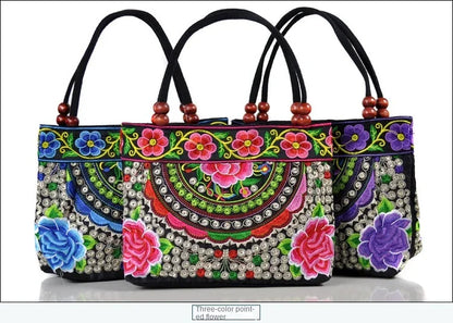 Small women's shoulder bag with floral embroidery, top handle, and flap with bead embellishments