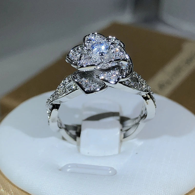 Elegant women's ring in premium 925 sterling silver featuring a three-dimensional design of intertwined roses and white cubic zirconia
