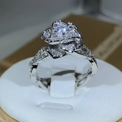 Elegant women's ring in premium 925 sterling silver featuring a three-dimensional design of intertwined roses and white cubic zirconia