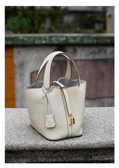 Classic, versatile, modern and elegant women's handbag in leather, with strap and padlock closure